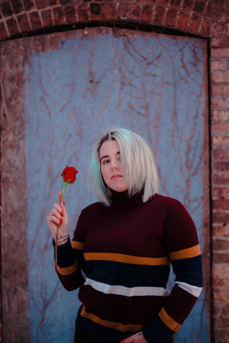 young adult, human, beautiful woman, long hair, 5K, sweater, figurine, plant, face, leisure activity, blossom, sweatshirt, holding, apparel, photo, sleeve