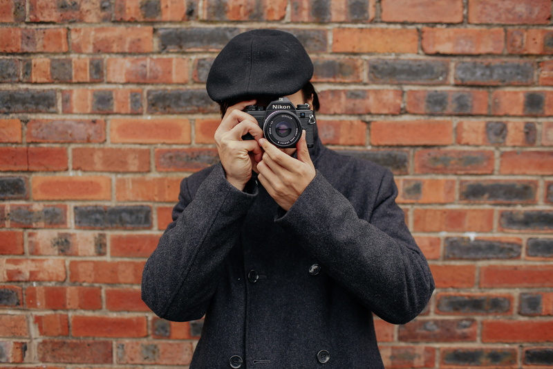 real people, wall - building feature, brick wall, person, males, face, obscured face, occupation, adult, camera, slr camera, standing, men, casual clothing