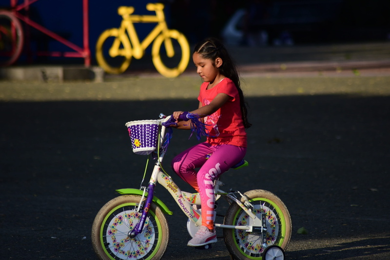latino, riding, girl, hairstyle, girls, 2K, side view, bicycles, outdoors, young adult, lifestyles, one person, transportation, women, full length, childhood