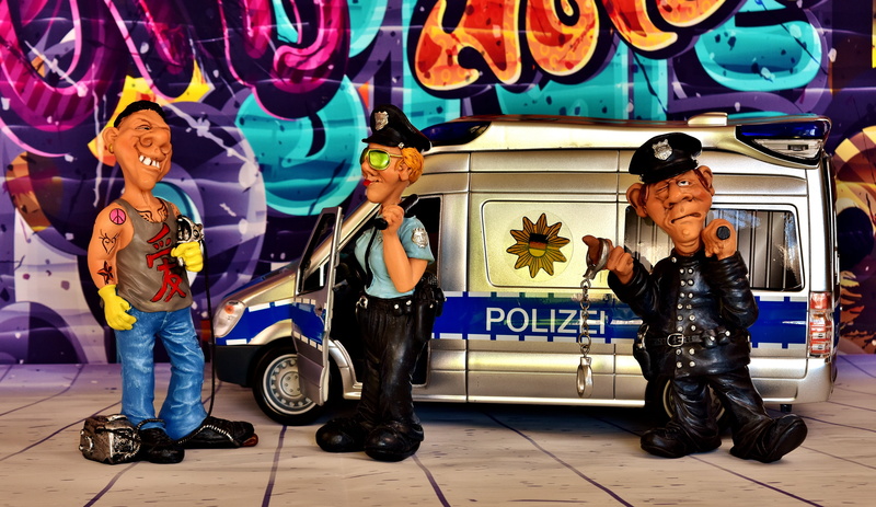 damage to property, three, adult, sitting, people, text, colorful, male likeness, representation, spray, figurines, mammal, police officers, full length