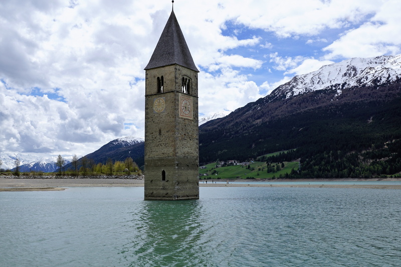 reschensee, outdoors, waterfront, tower, resia lake, blue, building, place of worship, beauty in nature, building exterior, tree, mountain, 5K, cloud - sky