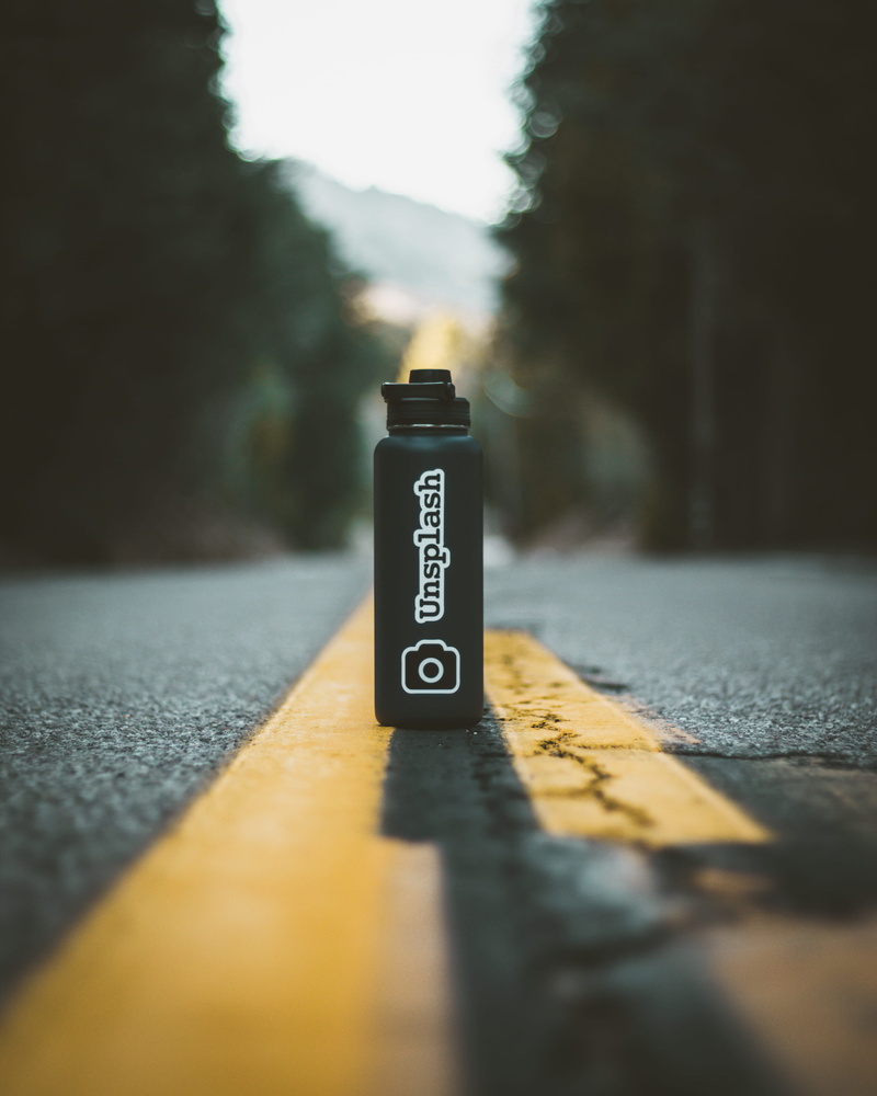 sign, close-up, selective focus, hydroflask, number, water bottle, black, sunlight, direction, information, western script, sky, tilt, tumbler, street