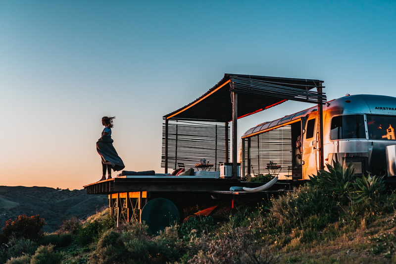 side view, real people, rv, teenager, lifestyles, portrait, daytime, land vehicle, golden hour, camping, dusk, built structure, dock, wood, outdoors, malibu