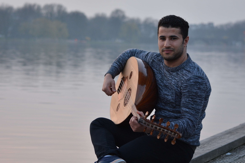 musical equipment, sitting, music, playing, musical instrument, outdoors, guitar, plucking an instrument, smile, lake, water, one person, young adult, leisure activity
