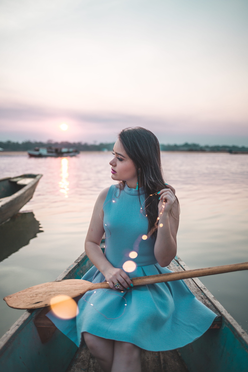 hairstyle, paddling boat, sunset, sky, lap, paddle, beautiful woman, young adult, rowing boat, blue, wooden, real people, hair, fairy lights, dress, portrait