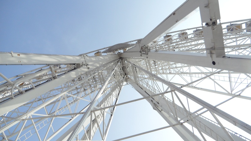 sunlight, excitement, carnival, entertainment, ride, built structure, recreation, directly below, spin, attraction, fair, clear sky, thrill, park, motion