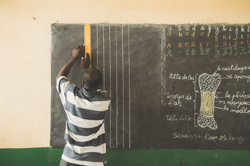 men, chalk, outdoors, man, french, arms raised, africa, casual clothing, human arm, writing, males, school, day, slate, real people, teacher, togo, standing