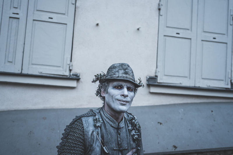 street performer, mime, costume, looking at camera, 5K, street, pari, young adult, gray, wall - building feature, smiling, young men, face painting, building