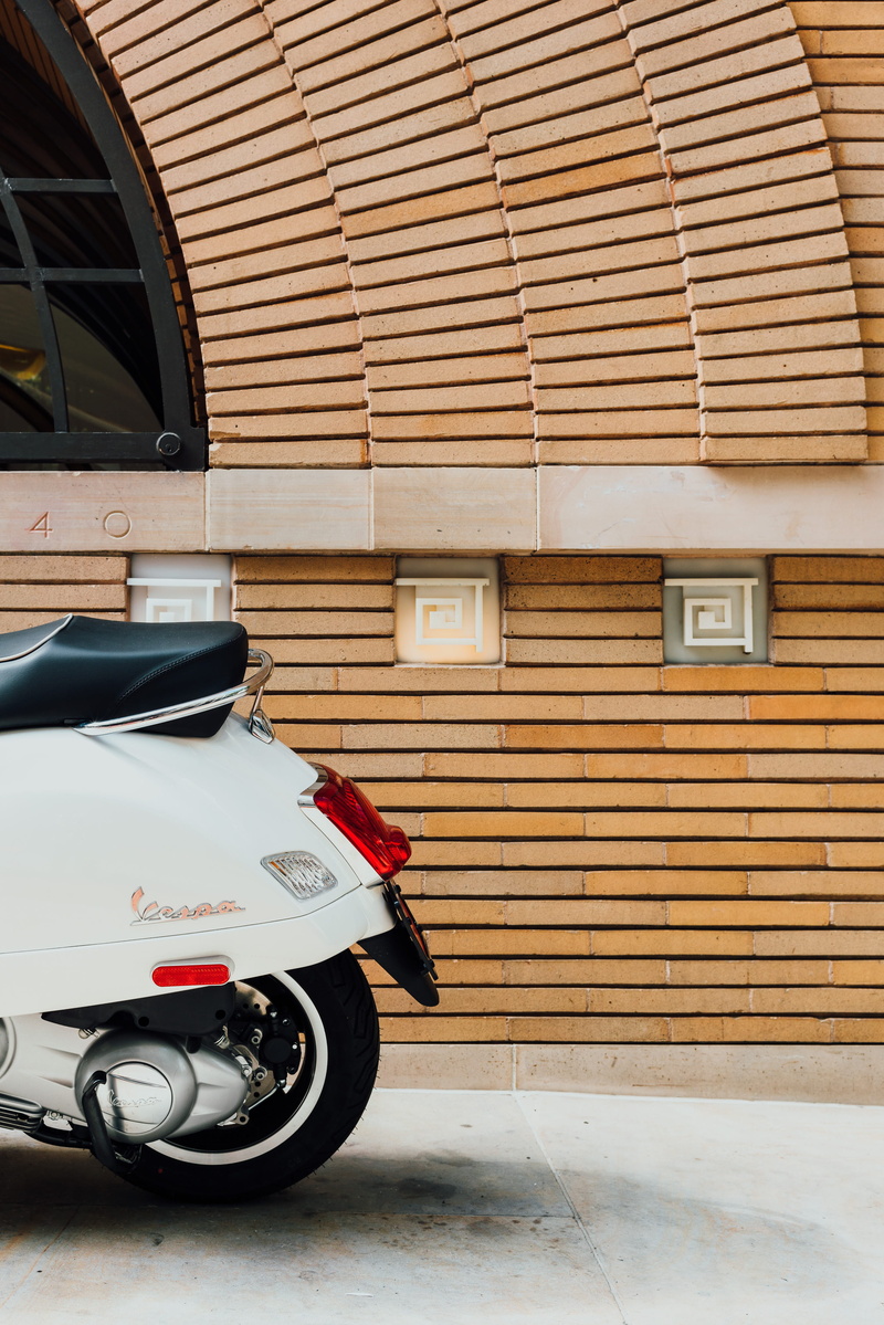 land vehicle, architetcure, beside, day, transportation, no people, building exterior, stationary, sidewalk, parked, car, modern wall, outdoors, scooter
