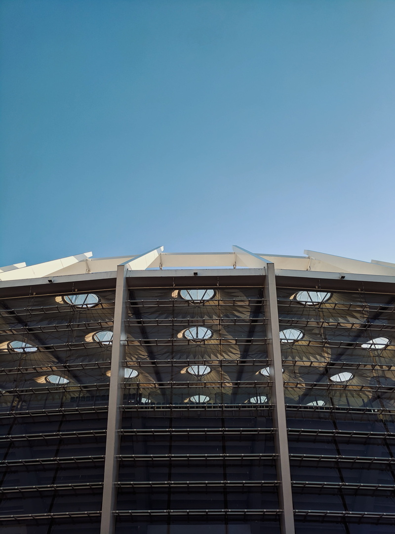 residential district, high rise, bullring, amphitheatre, geometric, blue, sunlight, metal, building, architecture, copy space, outdoors, office building