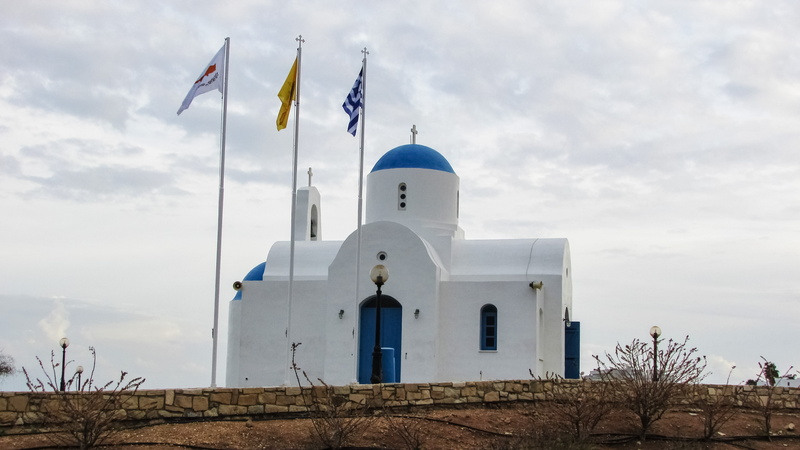 spirituality, cross, flag, sky, place of worship, outdoors, religion, built structure, nature, ayios nikolaos, belief, cloud - sky, architecture, no people