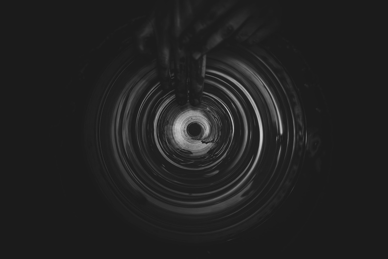 black color, rippled, night, spiral, black background, backgrounds, concentric, pottery, close-up, creator, shape, pattern, person, spinning, full frame