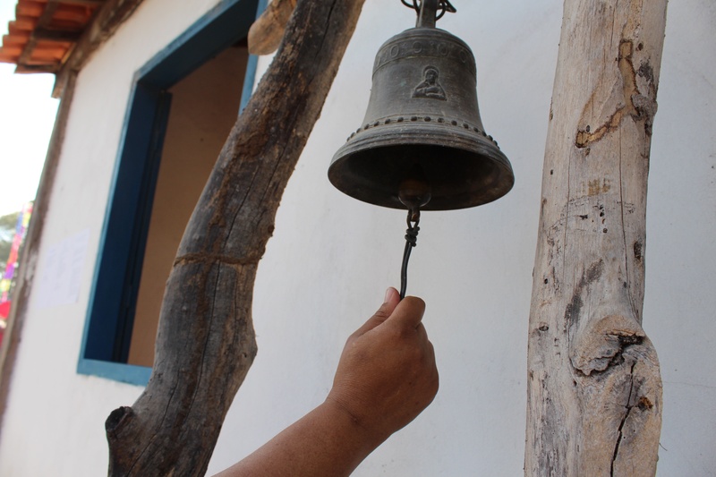 bell, close-up, finger, human limb, unrecognizable person, real people, human hand, built structure, hand, hanging, outdoors, architecture, metal, personal perspective
