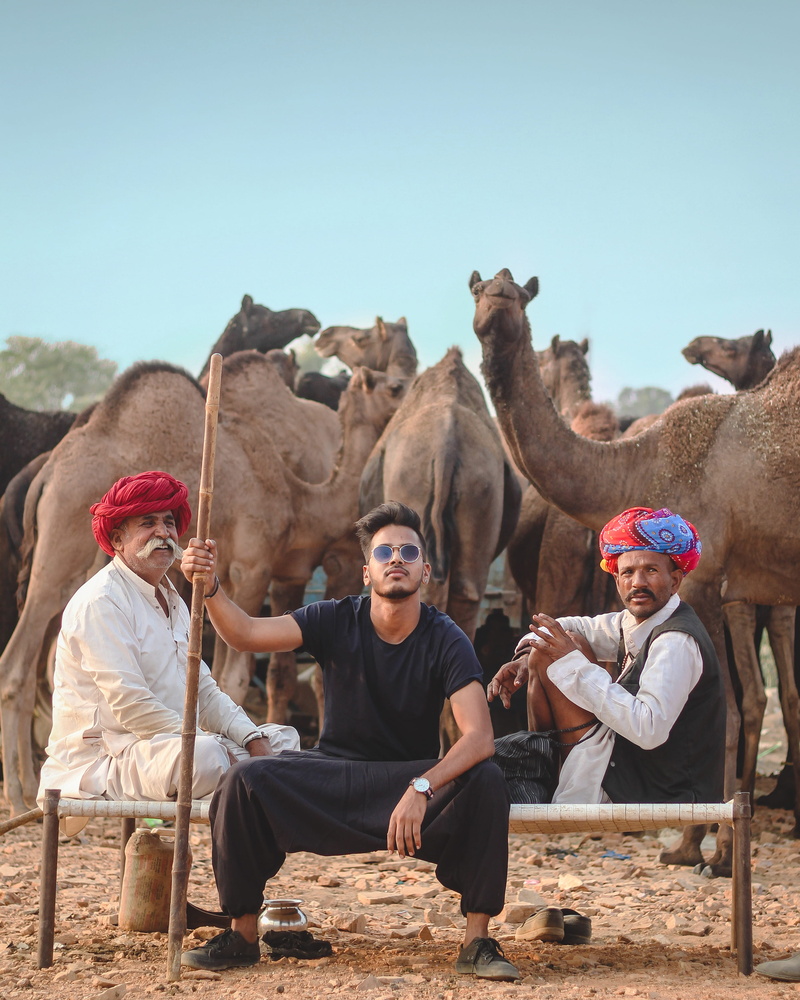 sky, camels, outdoors, daylight, animals, together, real people, camel, day, mammal, landscape, adult, leisure activity, behind, facial hair, sand, turban