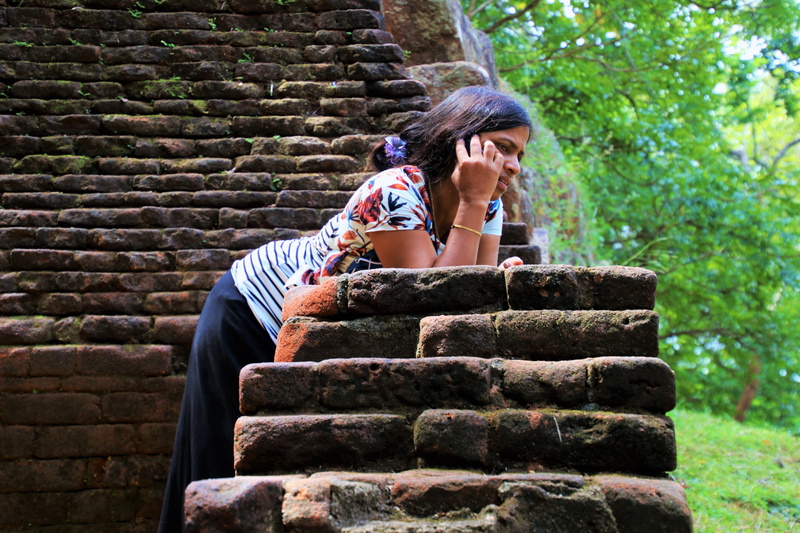 stairs, sri lanka, teenager, conversation, wall - building feature, solid, 5K, front view, outdoors, wall, sitting, phone, nature, one person, real people