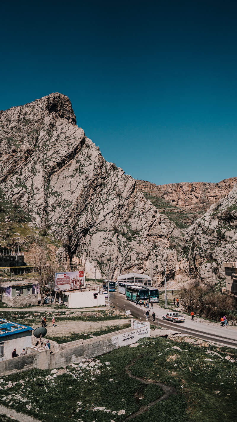 no people, iraq, vehicle, cliff, mountain, land, plant, people, kurdistan, day, scenery, hill, gathering, motor vehicle, formation, tree, transportation