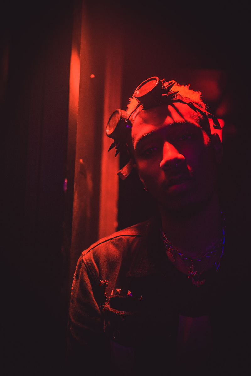 young men, dark, neon light, focus on foreground, streetstyle, man, real people, goggle, photo, close-up, warehouse, 4K, top, window, lost, one person