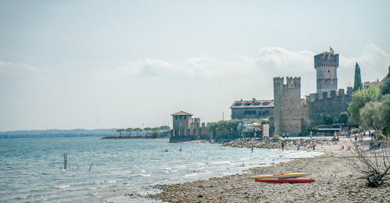 built structure, sea, cityscape, kayaks, travel destinations, architecture, summer, lombardy, city, sky, office building exterior, famous, scaliger castle