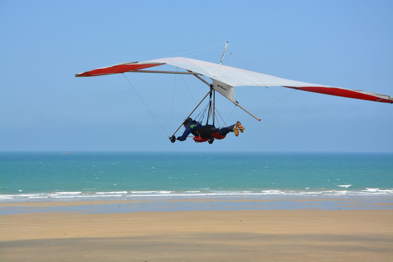 real people, 5K, beach of saint pabu, strong sensation, leisure, water, wings white red, air, leisure activity, wind, mid-air, beach, blue sky, unrecognizable person