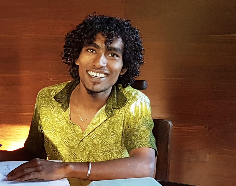 young man, galle, toothy smile, real people, teeth, smile, indoors, hair, hairstyle, casual clothing, sitting, travel, pilana, wireless technology, looking at camera