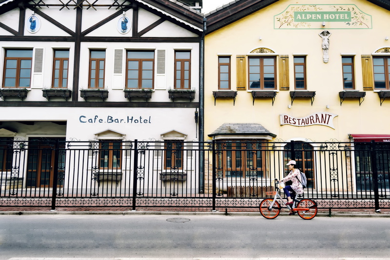 day, 5K, communication, architecture, mode of transportation, daytime, female, driving, building, building exterior, facade, men, street view, transport