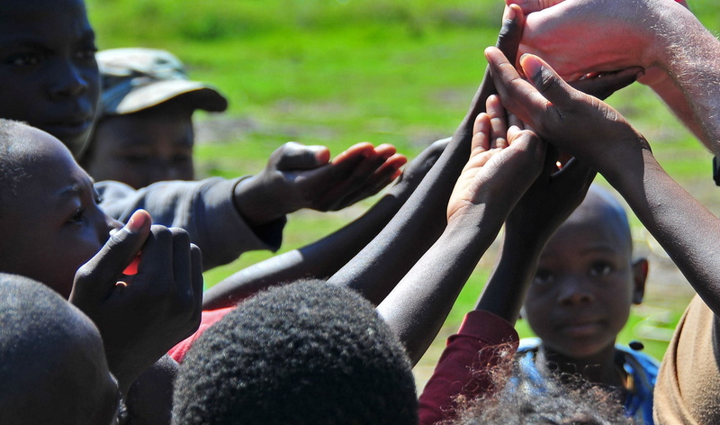 sport, human arm, day, boy, shirt, girls, boys, children, adult, cute, focus, poor, selective, giving candy, human body part, outdoors, haiti, people, group of people