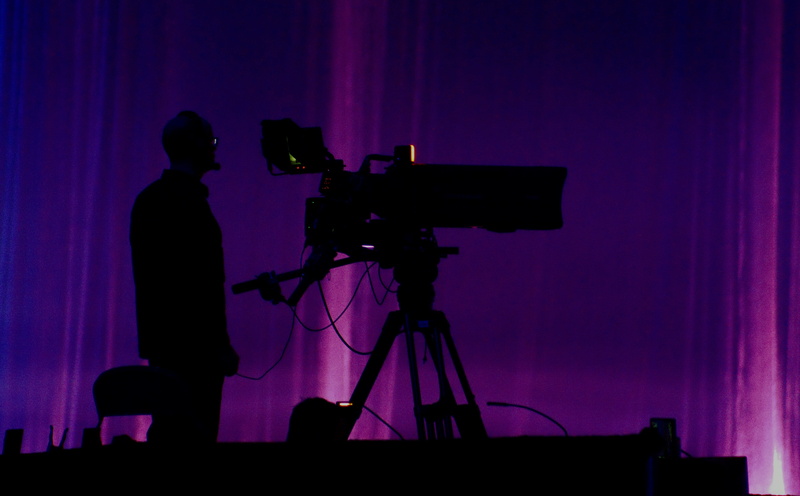 movie camera, near, photographer, video, behind the scenes, filming, indoors, stage, standing, film industry, tripod, television camera, one person, silhouette