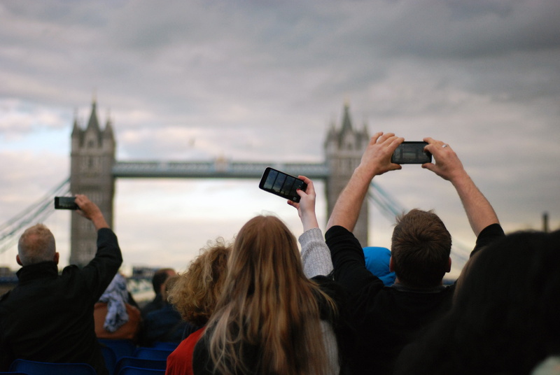 activity, smart phone, outdoors, communication, bridge, long hair, clouds, group, travel, sky, vehicle, connection, towers, photographing, curly hair, recreation