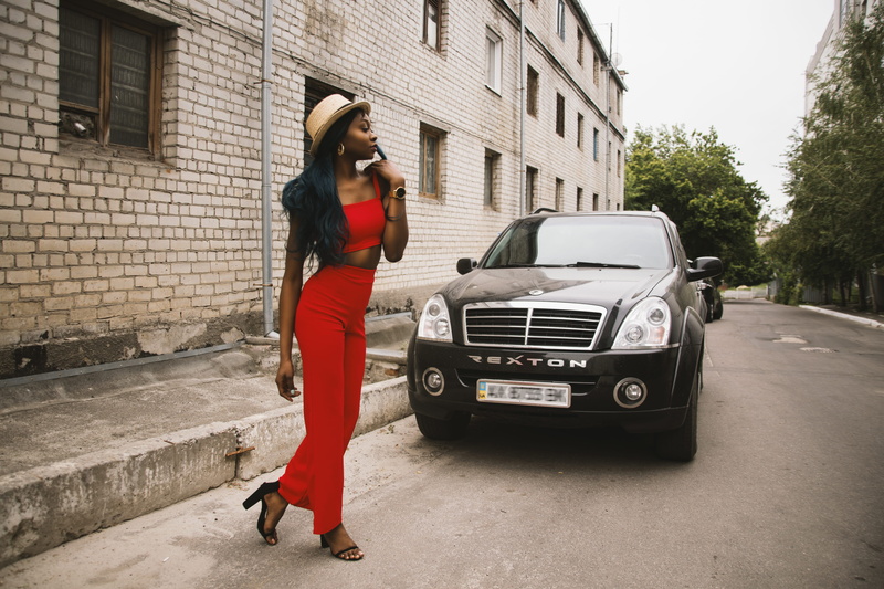 pavement, outdoors, clothing, suv, fashion, car, urban, walking, day, pose, road, building exterior, 5K, front, land vehicle, daytime, woman, architecture