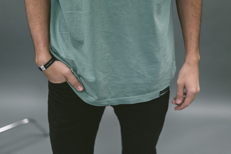 adult, holding, shoes, ripped, casual clothing, studio shot, church, photo shoot, young adult, tag, t-shirt, body part, clothing, front view, studio, midsection