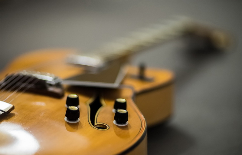 wood - material, single object, no people, guitar, still life, electric guitar, 1080P, musical instrument string, depth of field, table, studio shot, string