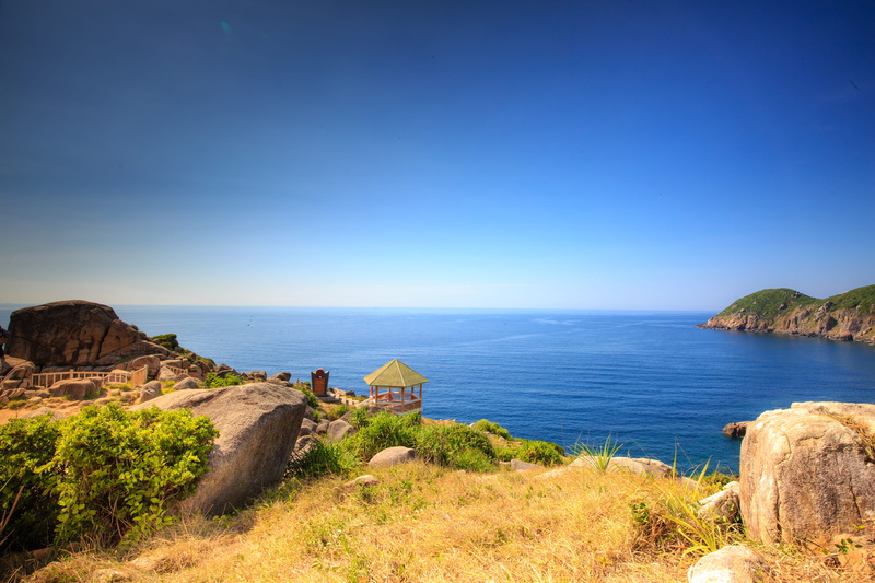 grass, tranquil scene, beach, peaceful, scenery, water, shore, horizon, day, nature photography, leisure activity, outdoors, stones, blue skies