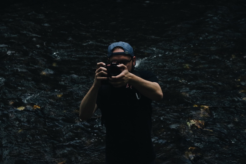 black, using, activity, three quarter length, male, glass, body, tree, young adult, glasses, front view, standing, waist up, shoot, nature, land, photographer