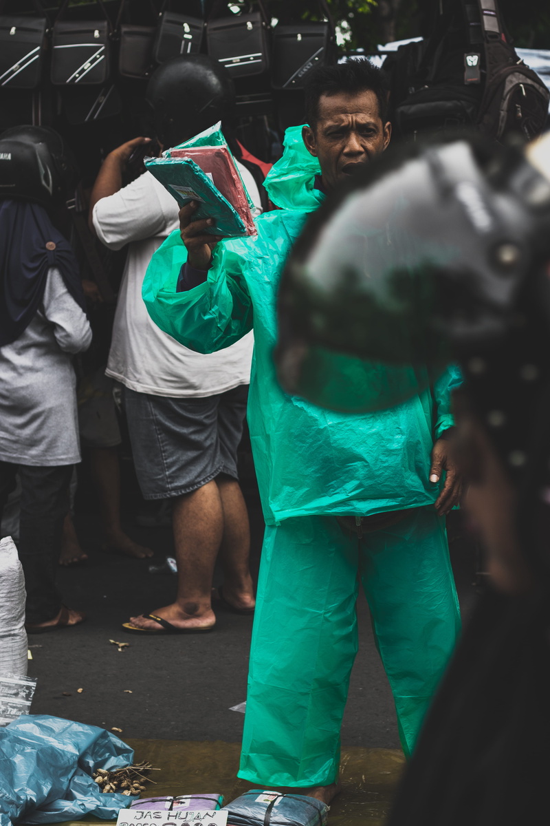 wearing, merchant, lifestyles, full length, standing, men, real people, street, costume, green, adult, city, uniform, clothing, rain, man, street photography