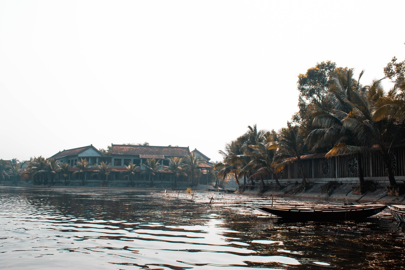 clear sky, land, nature, waterfront, mode of transportation, countryside, vehicle, coconut, person, nautical vessel, near, hotel, resort, building exterior