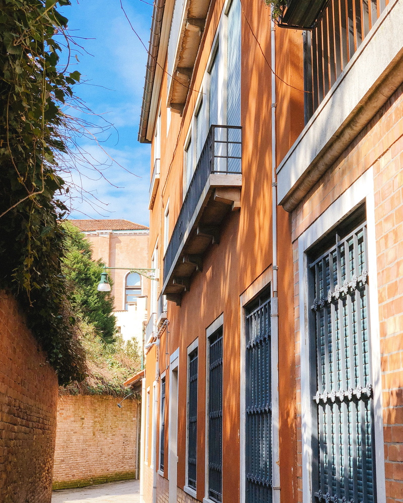 curtain, sunlight, outdoors, residential district, shutter, wall, walkway, day, nature, balcony, window shade, house, patio, architecture, building exterior