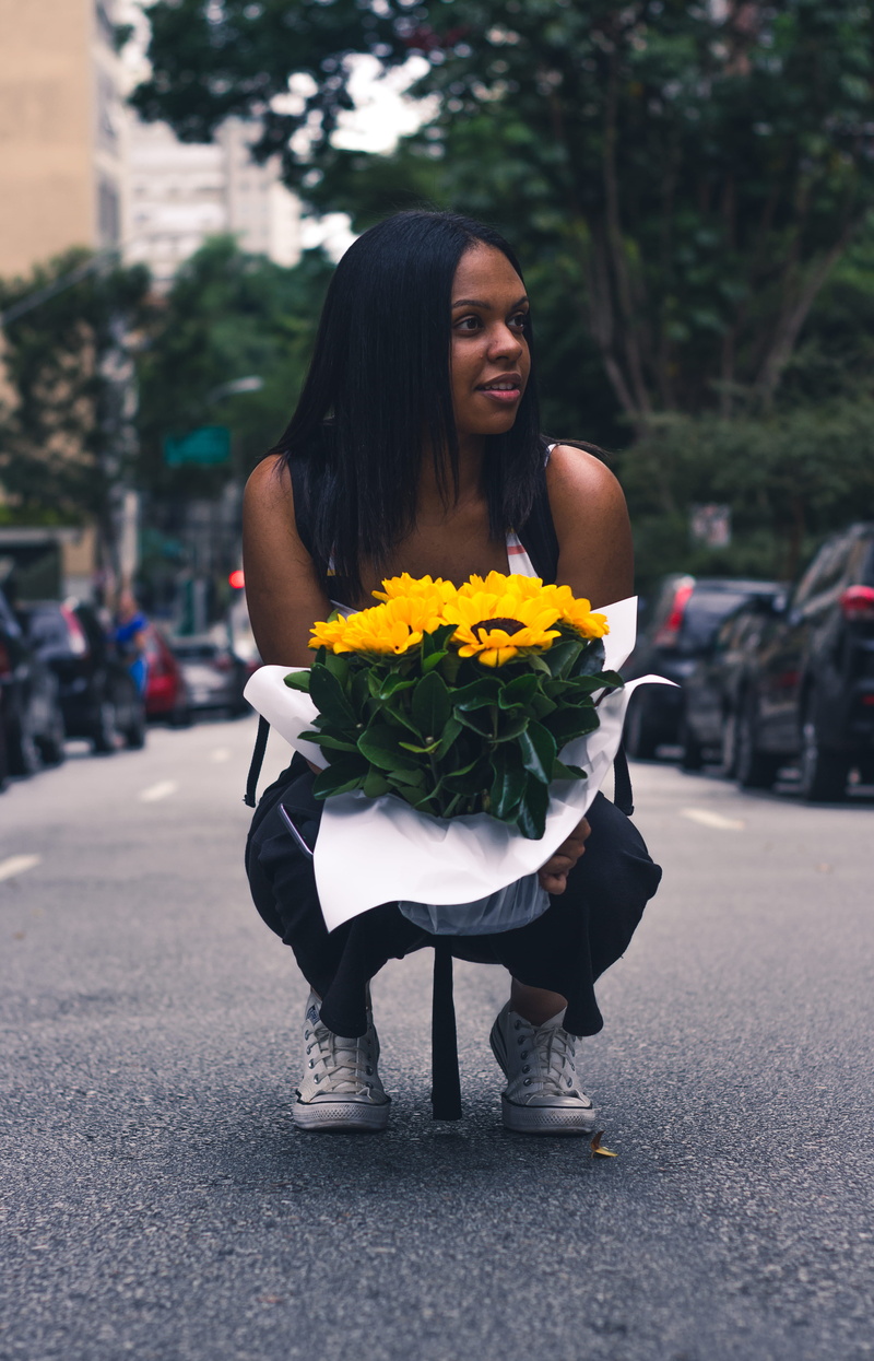 standing, flowering plant, wear, carrying, real people, women, 4K, street, day, beautiful woman, sunflower, stree, transportation, one person, plant, facial expression