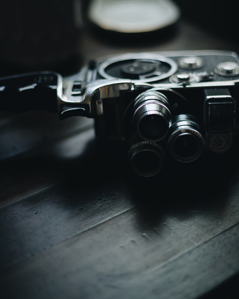 camera, weaponry, warning sign, wood, camera lens, finger, social issues, window, table, control, high angle view, digital camera, weapon, technology, lens cap