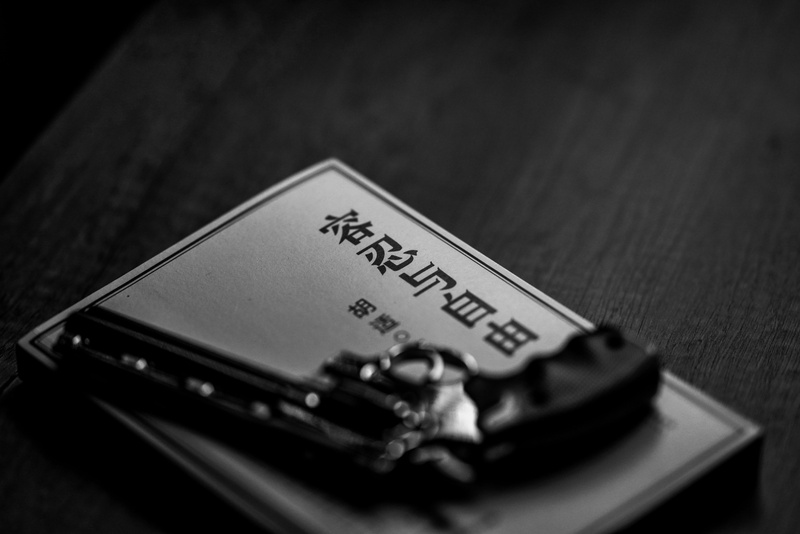 phone, razor, 8K, close-up, cell phone, selective focus, script, book, mobile phone, blade, non-western script, weaponry, high angle view, focus on foreground
