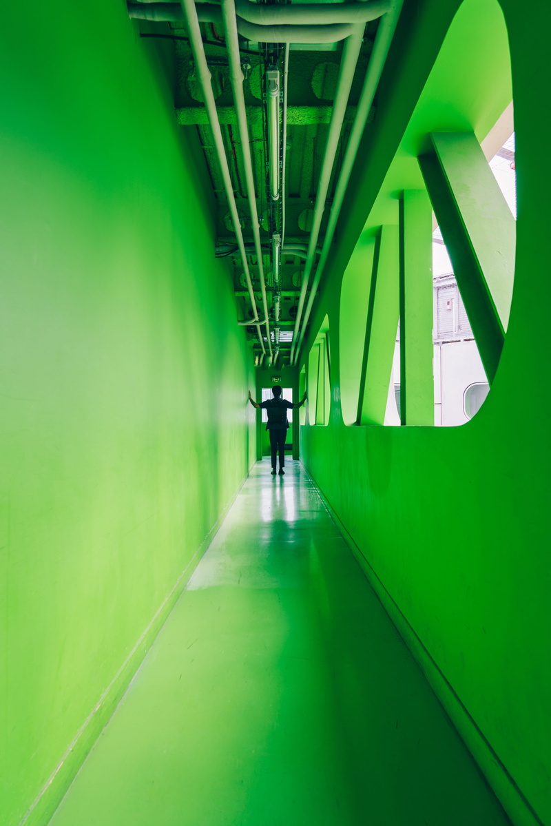 one person, banister, chair, bridge, hallway, green, person, floor, lighting, connection, real people, vanishingpoint, tunnel, lifestyles, colorful architecture