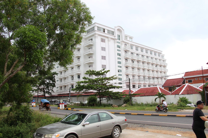 plant, city, tree, outdoors, incidental people, building exterior, mode of transportation, cambodia, built structure, hotel, road, residential district