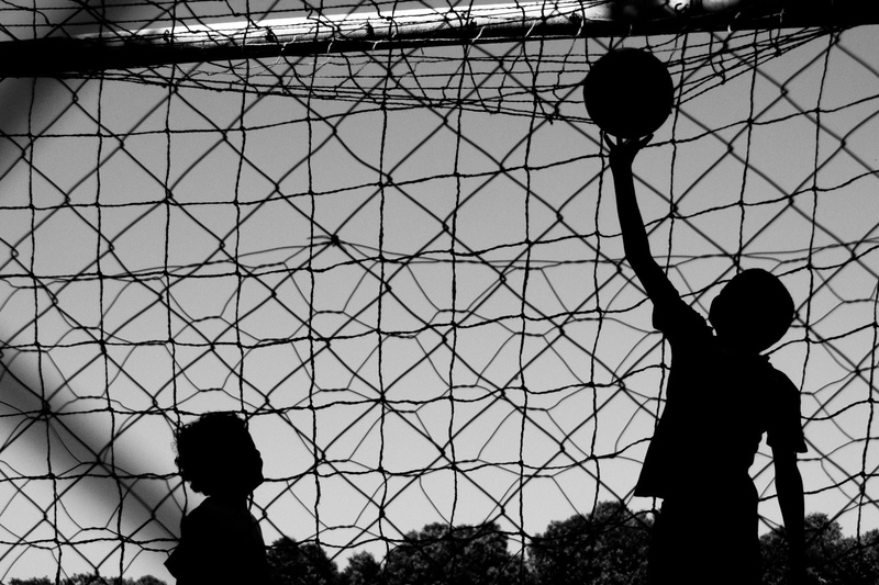 child, fence, real people, architecture, boys, play, childhood, barrier, day, silhouette, leisure activity, ball, chainlink fence, lifestyles, men, sky