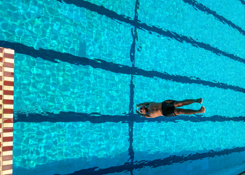 wet, high angle view, swimming lane marker, healthy lifestyle, relaxation, 2K, sunlight, water, leisure, turquoise colored, outdoors, one person, recreation