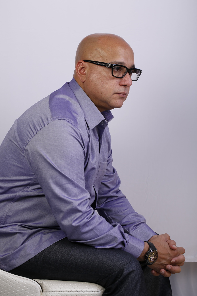 mature adult, person, one person, indoors, contemplation, sitting, serious, eyeglasses, clothing, three quarter length, shirt, man, indian, 5K, casual clothing