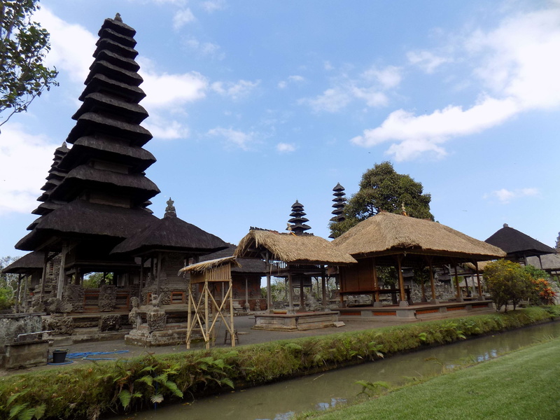 tourist, grass, pray, land, outdoors, belief, no people, building, tree, plant, built structure, place of worship, cloud - sky, nature, sky, hinduism, bali