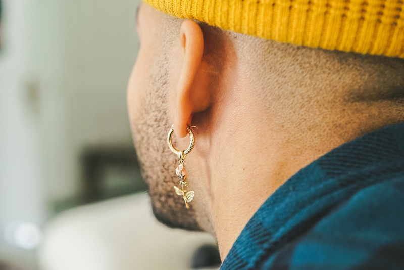 wearing, human face, unpaired, dangling, adult, profile view, lifestyles, men, jewelry, midsection, young adult, fashion, indoors, person, headshot, human body part