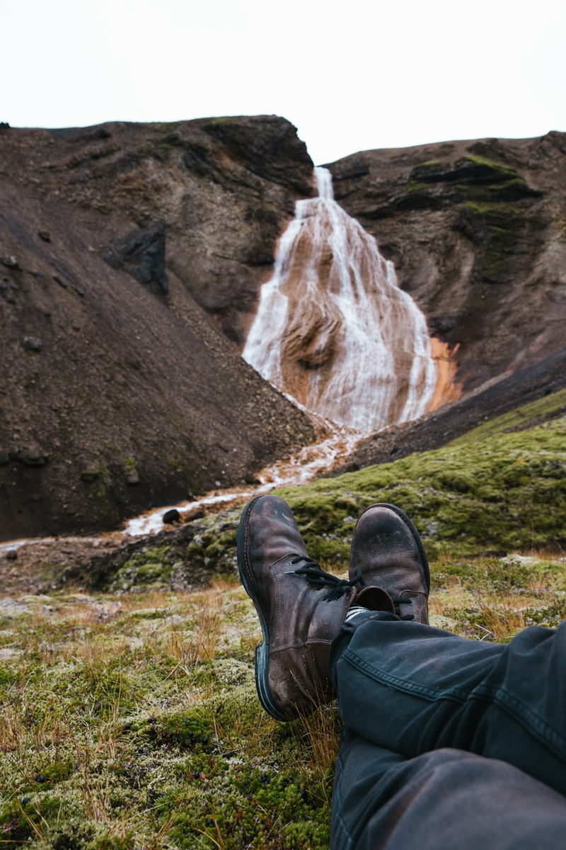 scenics - nature, day, stone, one person, man, moss, human leg, 2K, water, calm, shoes, casual clothing, human body part, travel, nature, outdoor, Waterfall