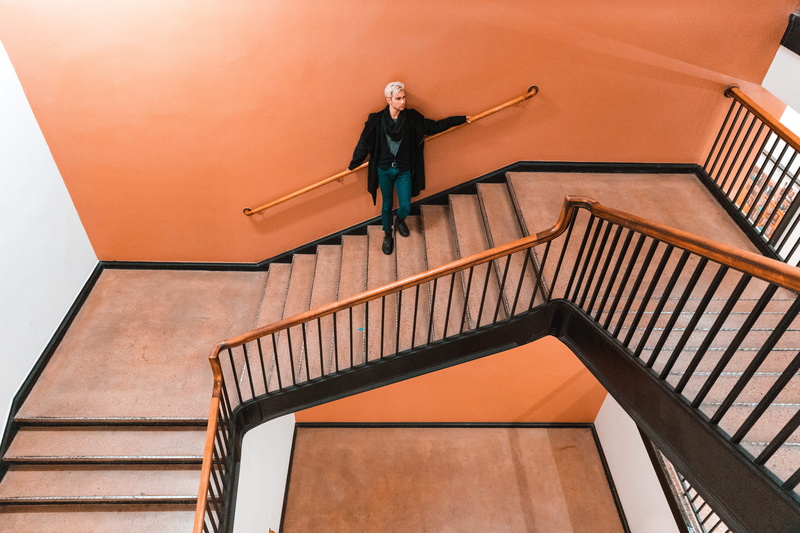 adult, orange, person, brown, wall, front view, standing, painted, railing, leaning, architecture, staircase, low angle view, full length, one person, handrail