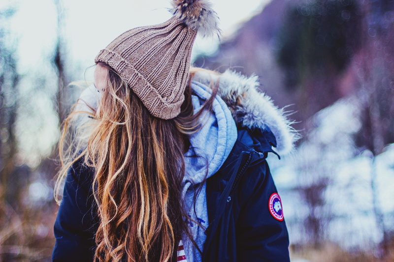 lifestyles, hood - clothing, young women, real people, knit hat, tree, hat, black, adult, focus on foreground, winter, long, clothing, dress, headshot