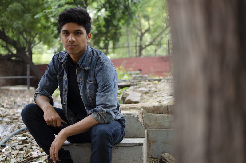 real people, teenage boys, day, adolescence, three quarter length, denim jeans, fashion, boy, street, sit, leisure activity, front view, one person, photoshoot